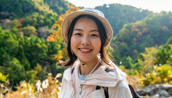 秋の山をトレッキング・登山する日本人女性の写真
