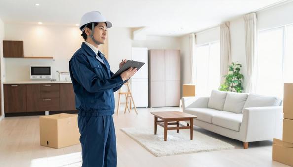 リビング・キッチンを点検する作業服の男性の写真