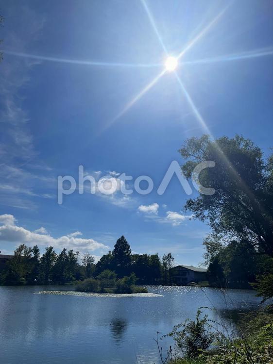 太陽のフレアと爽やかな青空と雲の背景素材 フレア,青空,空の写真素材