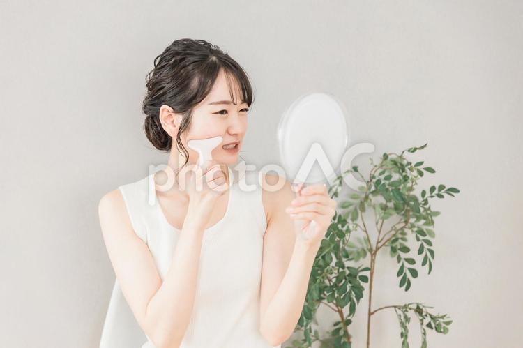 かっさでマッサージをする女性（痛い） かっさ,カッサ,フェイスマッサージの写真素材