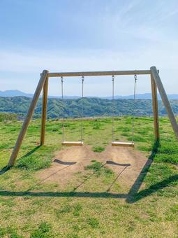 見晴らしの良いブランコ 見晴らしの良いブランコ 木製遊具,丘の上,青空の写真素材