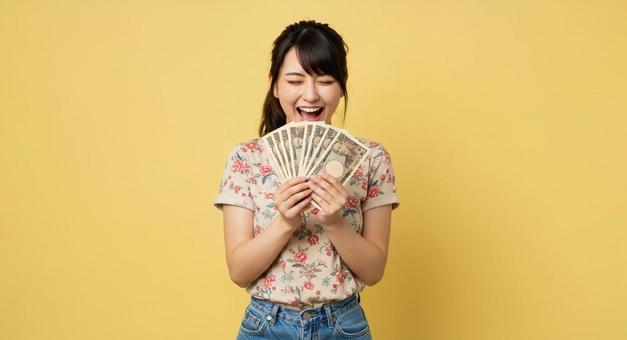 お札を手にして喜ぶ女性 お札を手にして喜ぶ女性の写真