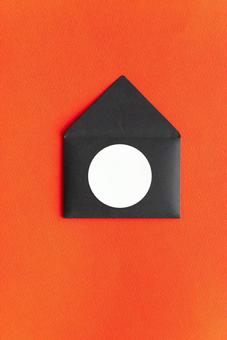 丸いラベルのついた黒い洋形封筒(赤背景) 丸いラベルのついた黒い洋形封筒(赤背景)の写真