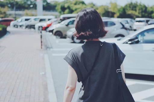 駐車場内を歩く女性後ろ姿 駐車場内を歩く女性後ろ姿 人物,女性,後ろ姿の写真素材