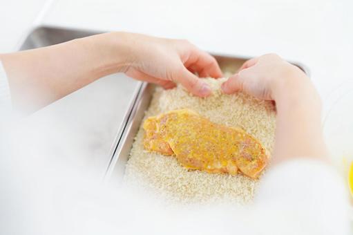 パン粉をつける作業をする人の手元 とんかつ,パン粉,衣づけの写真素材