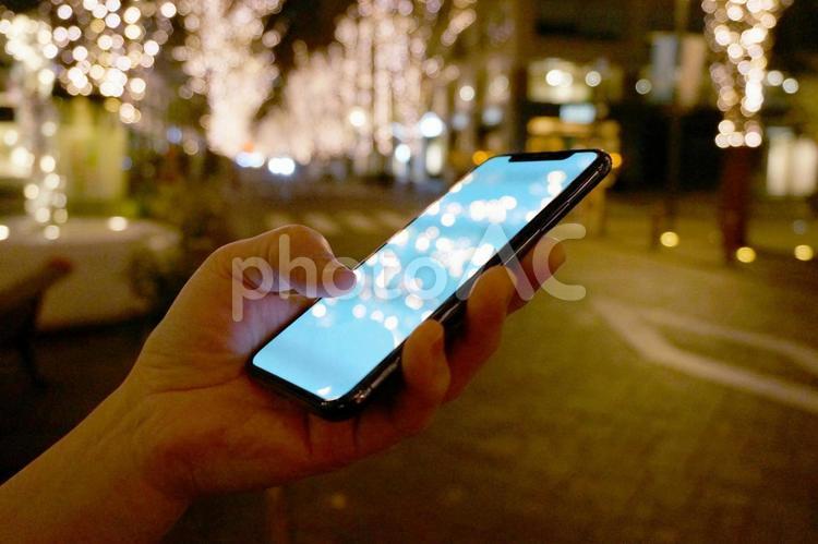 イルミネーションの街角でスマホを見る女性 デート,女子,女性の写真素材
