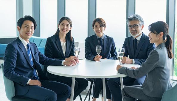 ビジネスパーソンが円卓でワインをかかげる ビジネスパーソンが円卓でワインをかかげるの写真