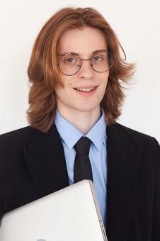 カメラ目線でパソコンを持つ笑顔男性 男性,外国人,ノートパソコンの写真素材