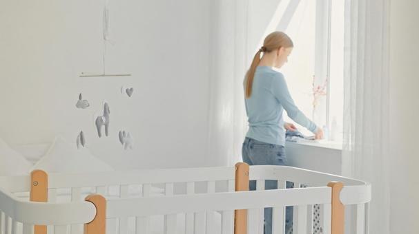 窓際で洗濯物を畳んでいる女性の横顔 窓際で洗濯物を畳んでいる女性の横顔の写真