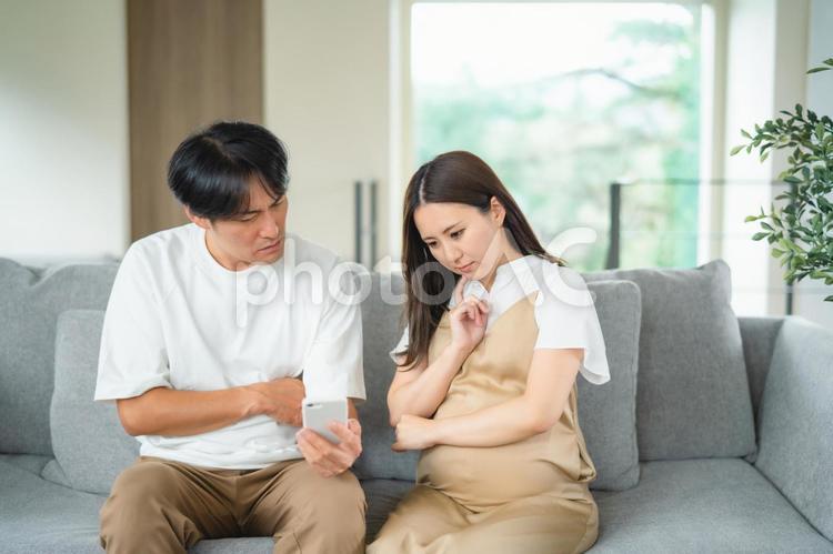 スマホを見る妊婦と男性（悩む） 妊婦,妊娠,夫婦の写真素材