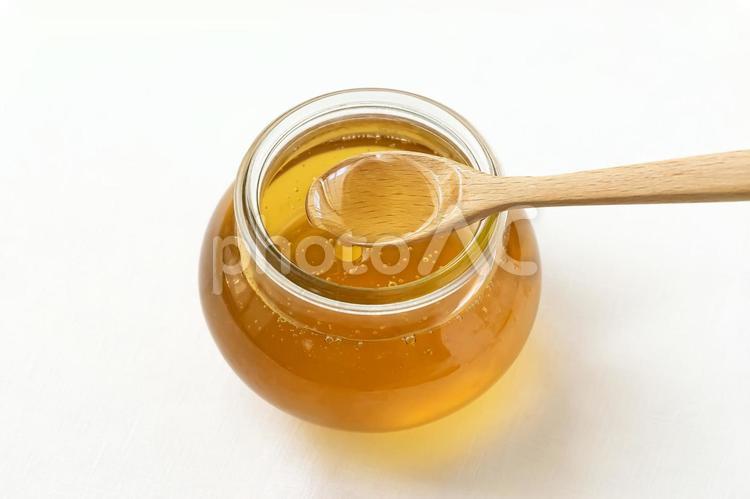 ハチミツ+スプーン　上から ハチミツ,蜂蜜,木のスプーンの写真素材