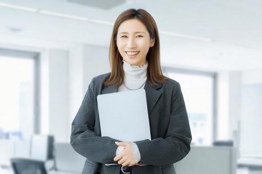 パソコンを持つ女性・ビジネスウーマン 女性,パソコン,笑顔の写真素材