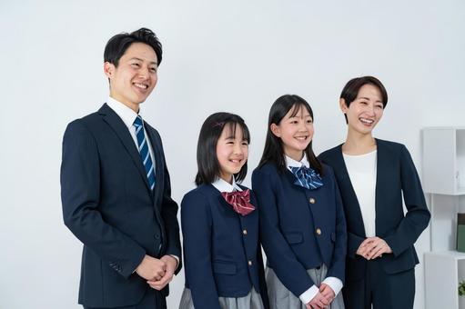 スーツを着た男女と制服を着た女の子二人 入学式,父母,母親の写真素材