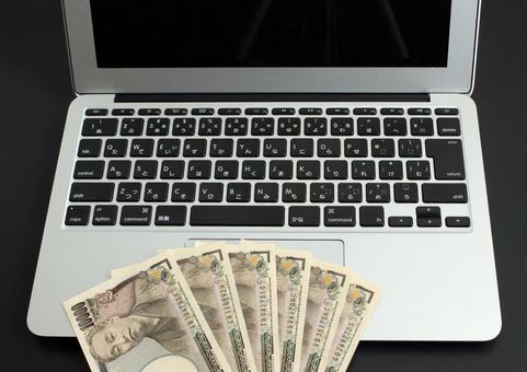 パソコンと日本円紙幣 パソコンと日本円紙幣 パソコン,ノートパソコン,キーボードの写真素材