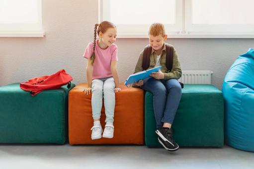 ノートを見せて笑顔の生徒たちと太陽 男の子,女の子,子どもの写真素材