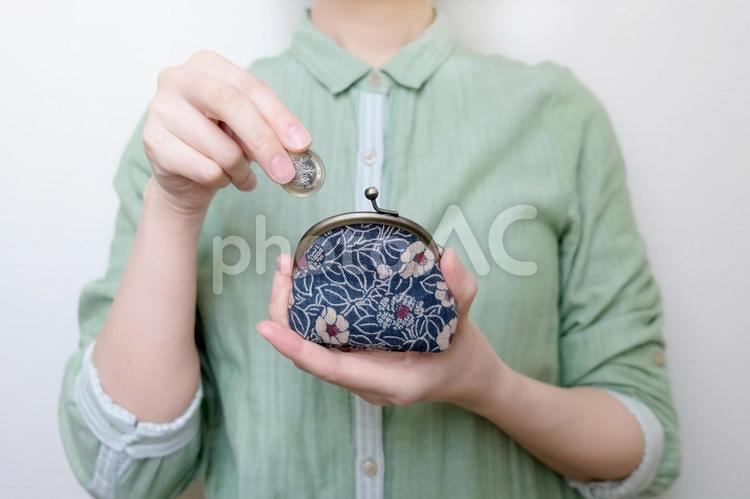 がま口に小銭を入れる女性の手元（上半身） 貯金,節約,がま口の写真素材