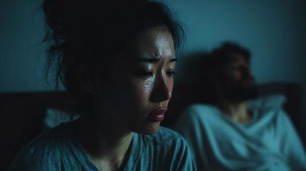 寝室の夫婦間に漂う緊張の写真