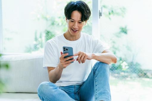 スマホを操作する男性 スマホを操作する男性 スマホ,笑顔,男性の写真素材