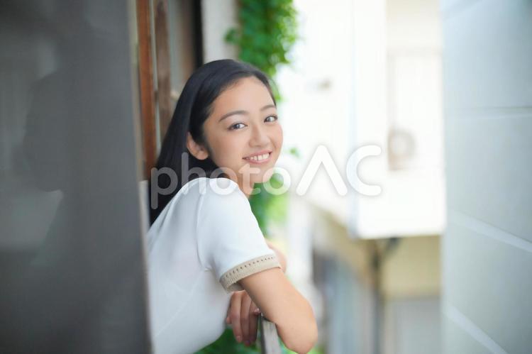窓から顔を出すカメラ目線女性 女性,日本人,窓の写真素材