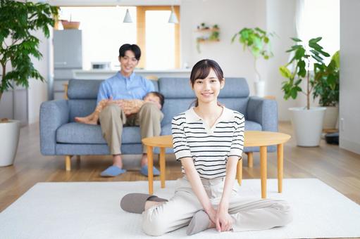 リビングで座るカメラ目線の夫婦 リビングで座るカメラ目線の夫婦の写真