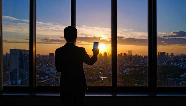 都市背景に画面を見ているビジネスマン 都市背景に画面を見ているビジネスマンの写真