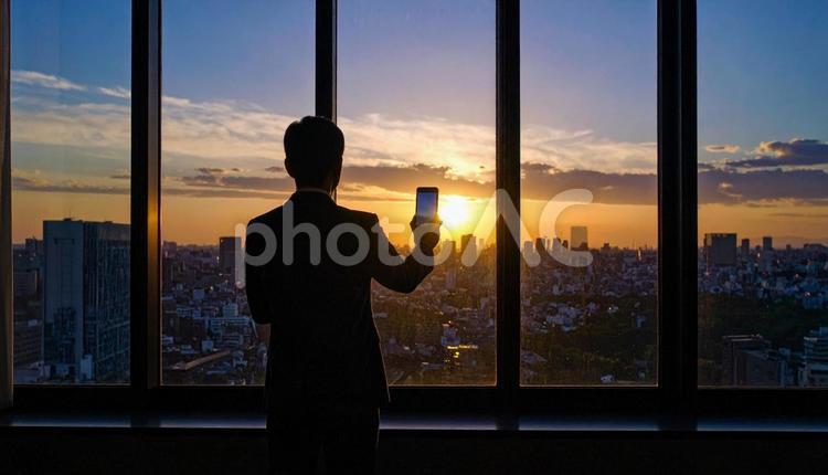 都市背景に画面を見ているビジネスマン 都市,高層ビル,起業家の写真素材