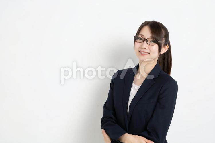 両手を前に組み笑っているメガネのビジネスウーマン（コピースペース） 女,女性,日本人の写真素材