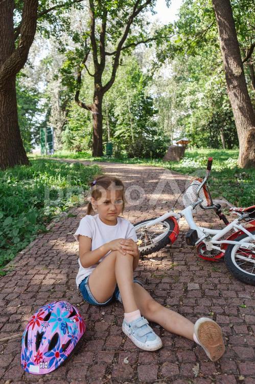 自転車で転んで膝を押さえて痛がって女の子 自転車,子ども,女の子の写真素材