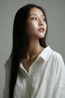 静かな表情でカメラを見つめる女性 静かな表情でカメラを見つめる女性の写真