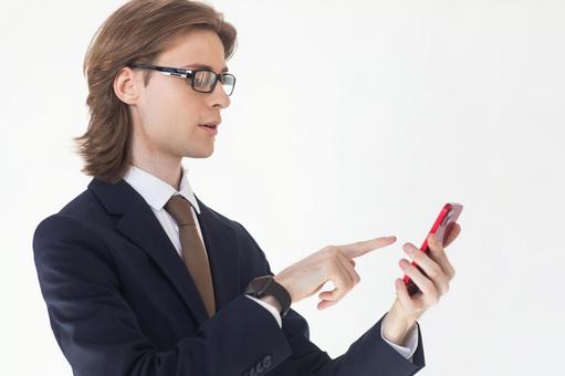 スマートフォンを使うスーツにメガネの横向きの男性 男性,外国人,欧米人の写真素材