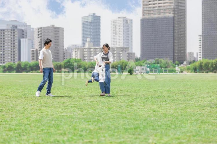 手を繋いでグルグルをして遊ぶ親子 ファミリー,家族,人物の写真素材