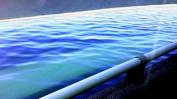 穏やかな青い水面を望む防波堤 穏やかな青い水面を望む防波堤の写真