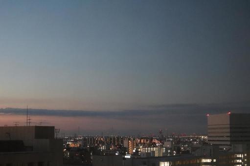 ネオンのビル群の街並みと夕暮れの空の風景 ネオンのビル群の街並みと夕暮れの空の風景の写真