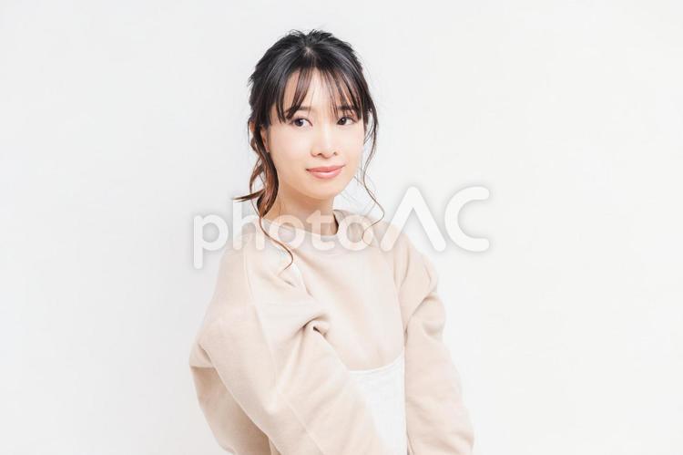 白い背景の前に立ってポーズをとる若い女性 女性,白背景,立つの写真素材
