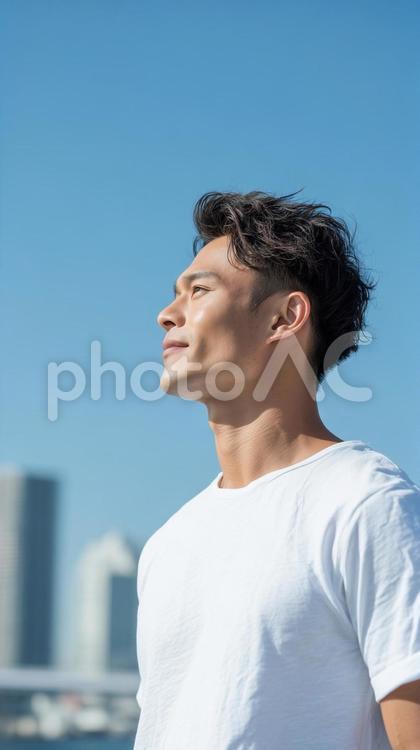 青空を見上げる白Tシャツの爽やか男性 男性,ポートレート,青空の写真素材