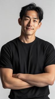 腕組みで自信に満ちた黒いTシャツの男性 腕組みで自信に満ちた黒いTシャツの男性の写真
