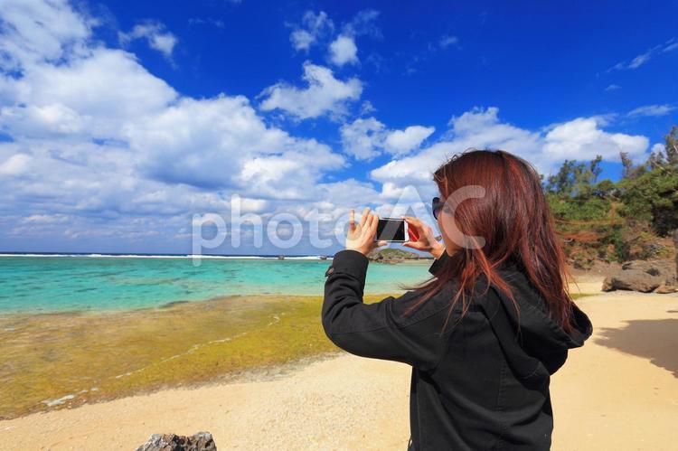 海を撮る女性(観光客) ビーチ,海,空の写真素材