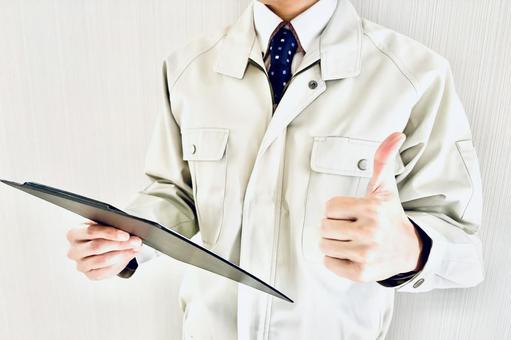 バインダーを持って親指を立てる作業着男性 男性,解決,グッドの写真素材