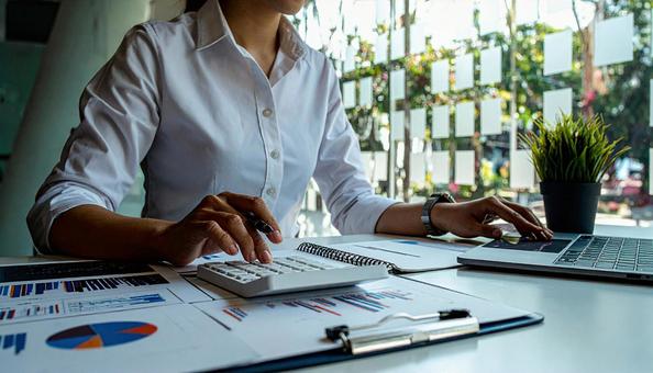 計算機を使う白いシャツのビジネスパーソン 計算機を使う白いシャツのビジネスパーソンの写真