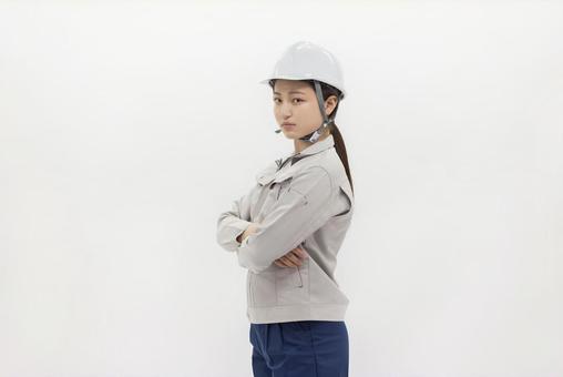 腕組みをする作業服の女性 腕組みをする作業服の女性 女性,ヘルメット,作業服の写真素材
