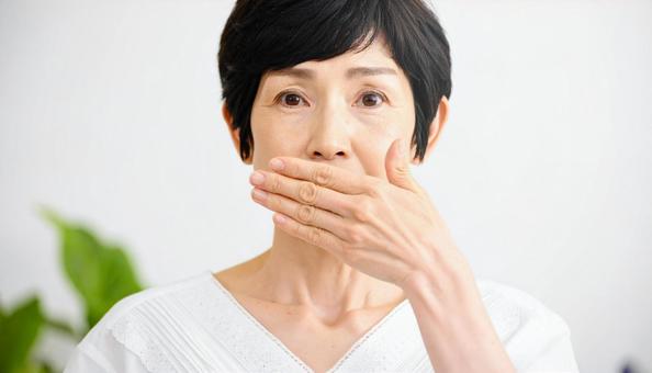口を手で覆って驚いた表情の日本人女性 口を手で覆って驚いた表情の日本人女性の写真