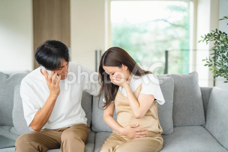 出産直前の妊婦の病院を探す男性（スマホ） 破水,陣痛,妊婦の写真素材
