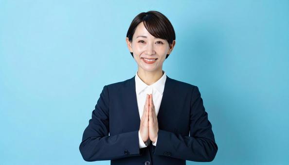 両手をあわせお願いするビジネスウーマン 両手をあわせお願いするビジネスウーマンの写真