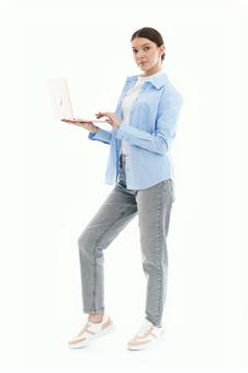 パソコンを持ちカメラ目線の女性 パソコンを持ちカメラ目線の女性の写真