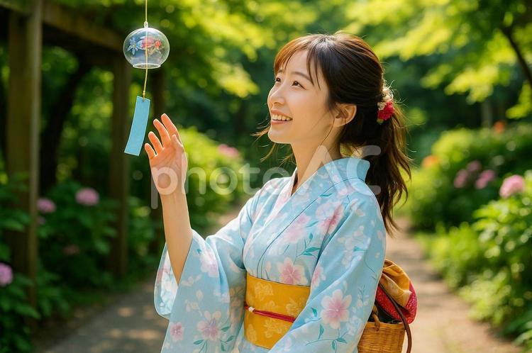 風鈴に手を伸ばす浴衣姿の女性 浴衣,女性,日本人の写真素材
