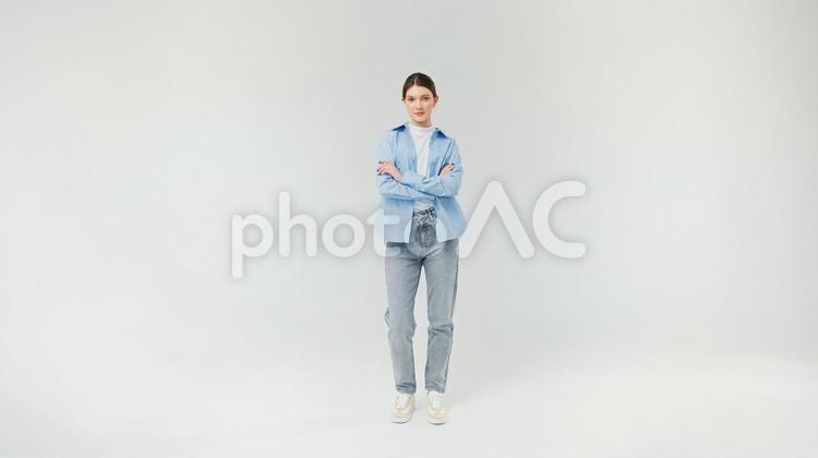 カメラ目線で腕組みをするジーンズ女性 女性,腕組み,真顔の写真素材