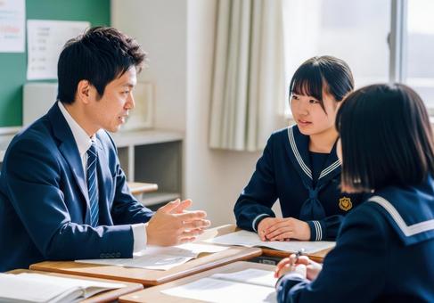 教室で生徒に指導する教師と学生の写真