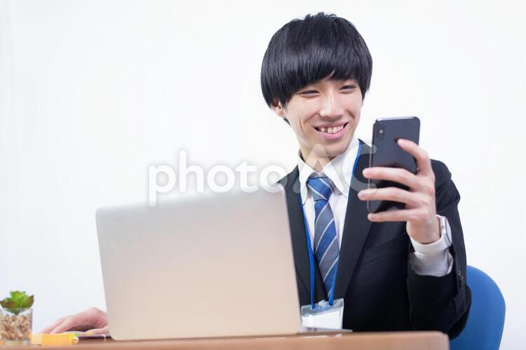 笑顔でスマホを確認する若い日本人ビジネスマン マスク,健康,ヘルスケアの写真素材