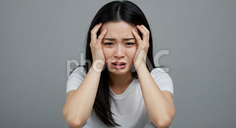 頭を抱えている女性じょ 頭を抱える,不安,ショックの写真素材