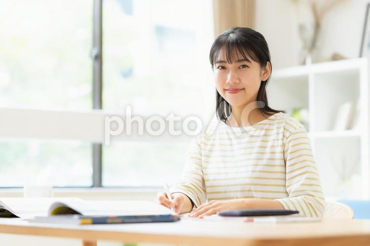 リビングで勉強をする大学生の女性 教育,勉強,女性の写真素材